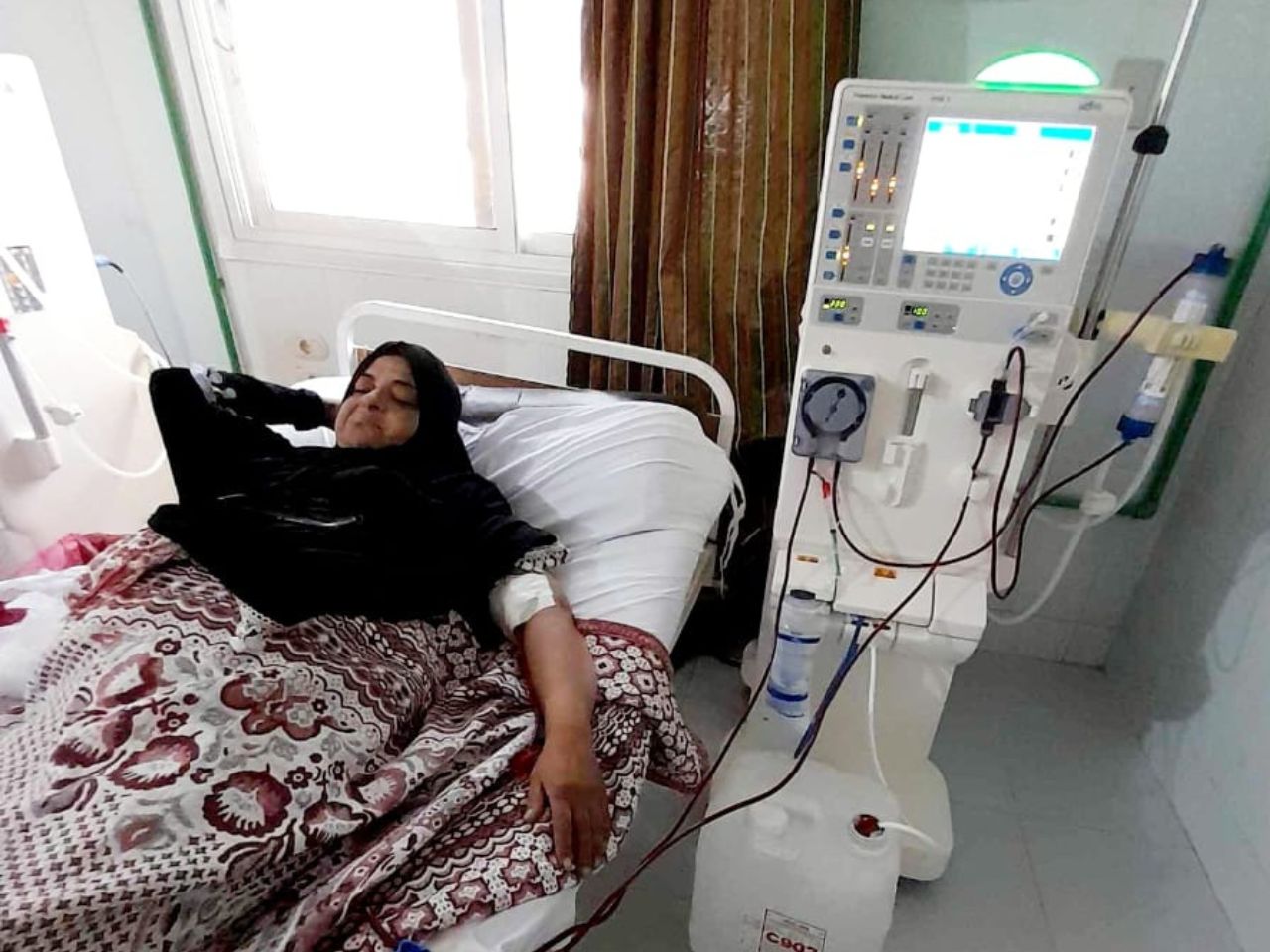 muslim women in hospital bed receiving dialyisis